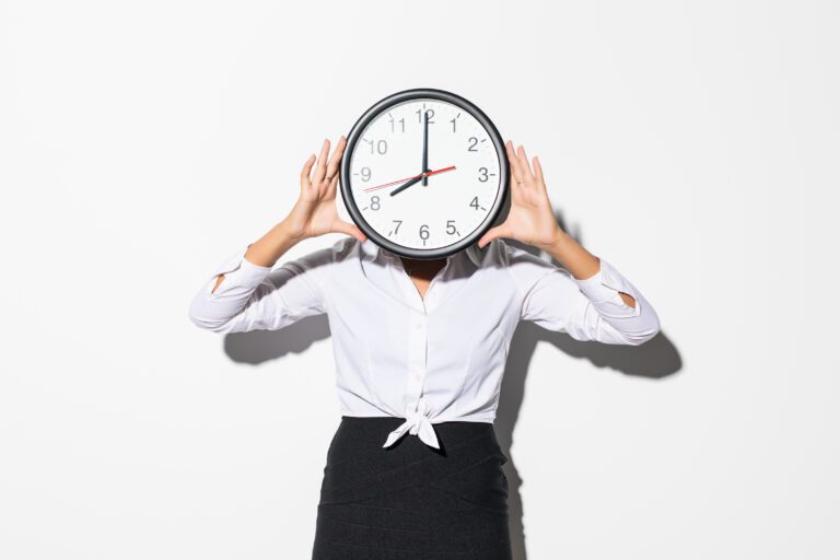 Photo Of Funny Woman In White Shirt And Black Skirt Covering Face With Big Round Clock Isolated Over White Background